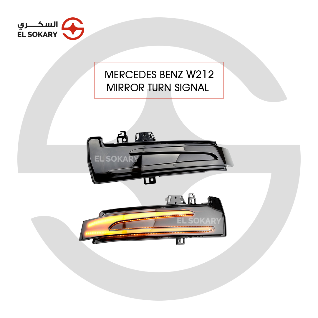 A pair of smoked LED mirror turn signal indicators for a Mercedes-Benz W212, showing one unit in its off state and the other illuminated with a bright amber light bar.